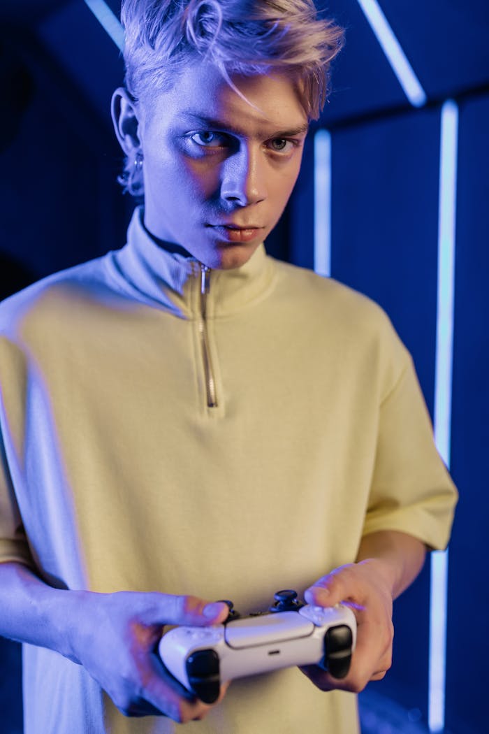 A young man intensely playing video games indoors with a game controller.